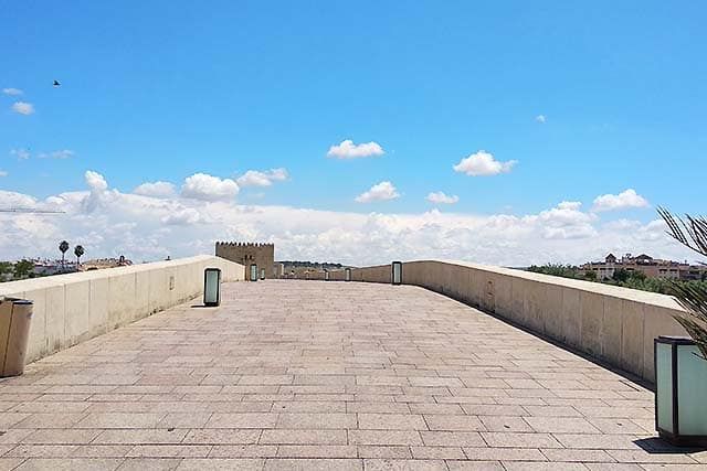 dentro del puente romano de Córdoba. En la travesía se pueden ver los puntos de luz y las papeleras