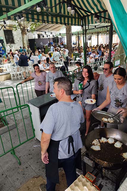 vecinos friendo huevos en "La Huevá" con la TV grabando